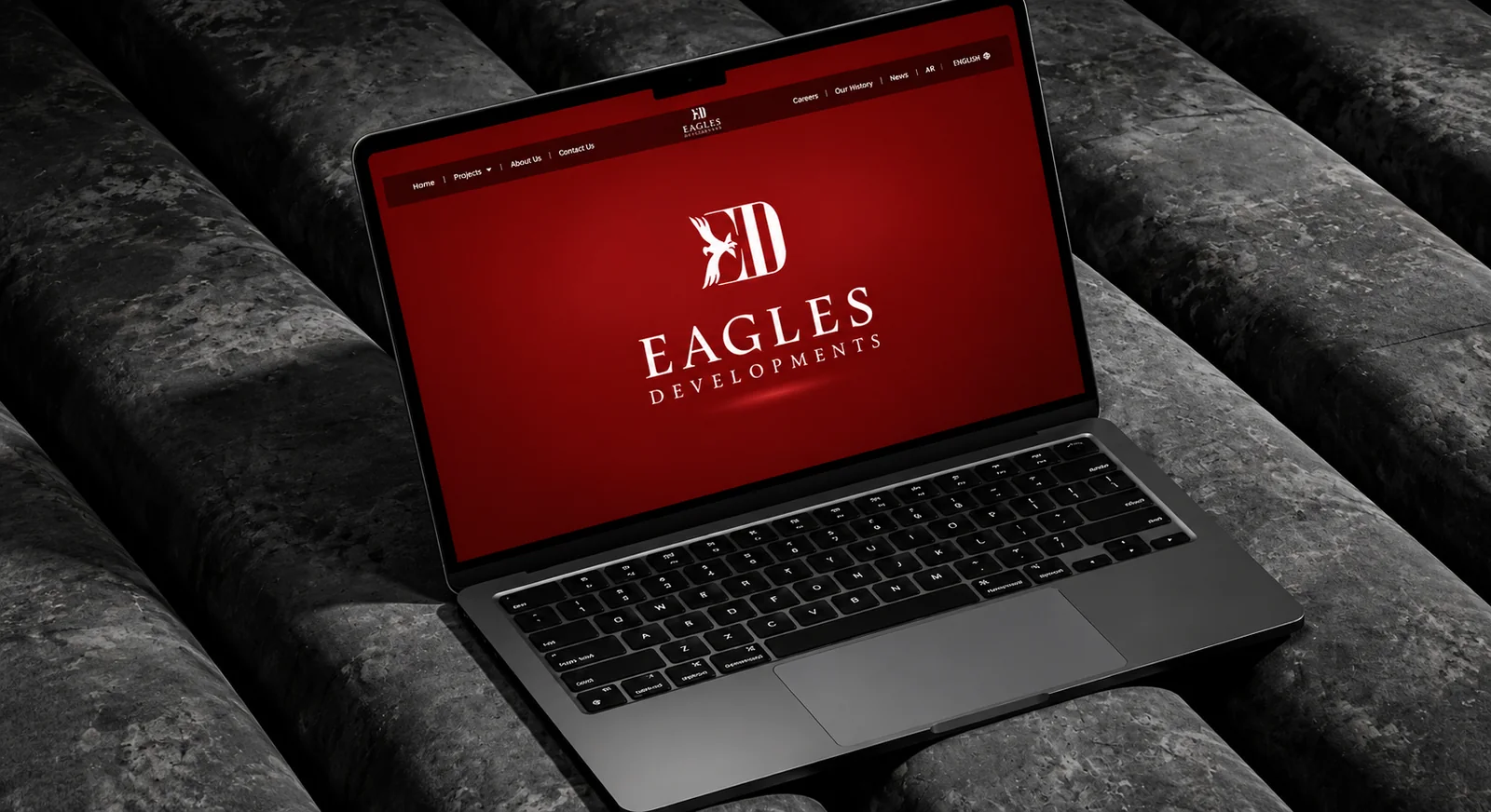 موقع Eagles Developments على شاشة لابتوب، وصفحته الرئيسية الحمراء تحمل شعار Eagles.