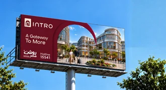 An Intro billboard against a blue sky: “A Gateway To More”, the Roshan Masr logo and the 15541 hotline beside the project seen through its arch.