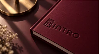 A burgundy hardcover book embossed with the Intro logo.